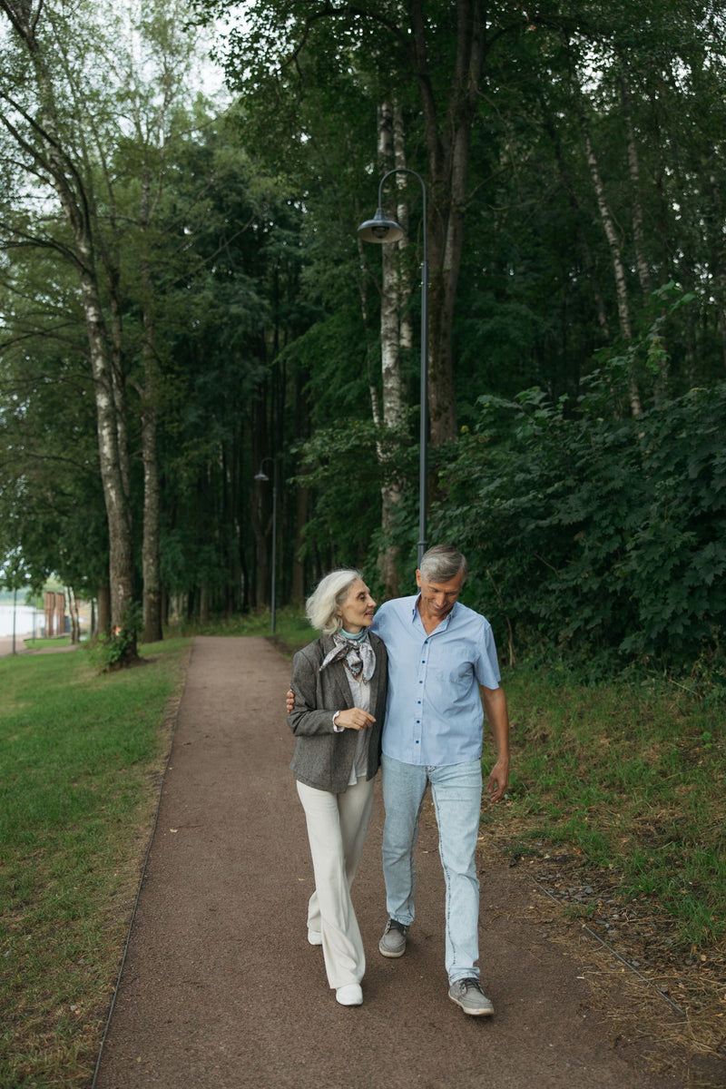 Couple de seniors marchant bras dessus bras dessous dans un parc